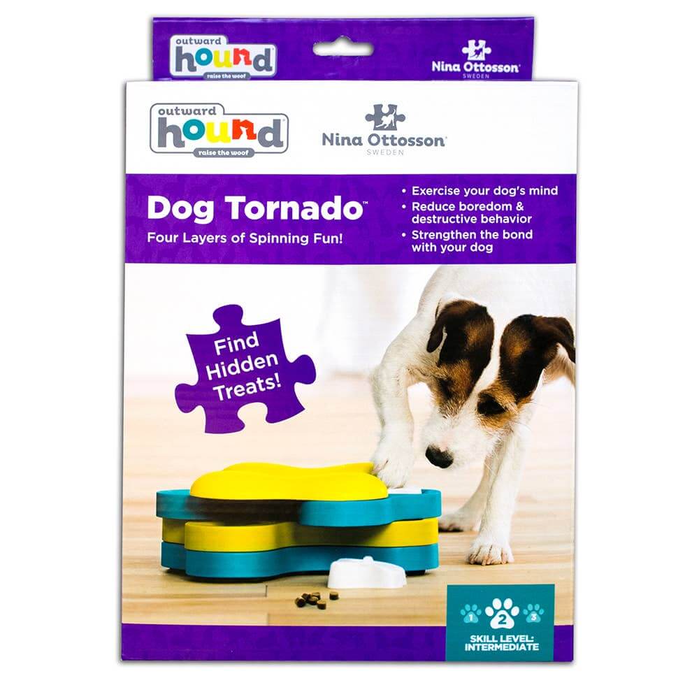 Outward Hound Dog Tornado puzzle toy in retail packaging with a dog sniffing the toy on wood floor.