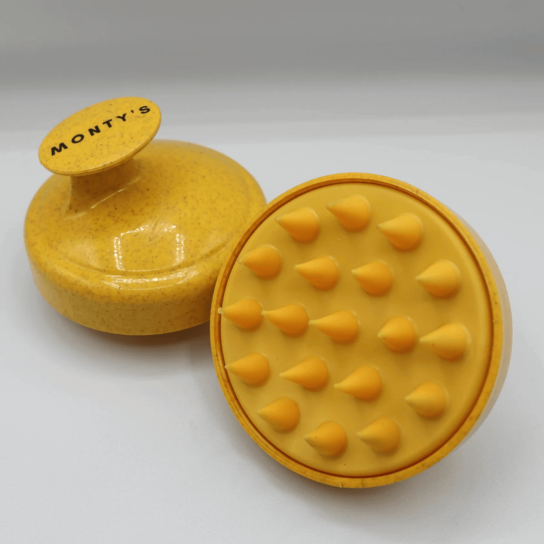 Monty's yellow dog shampoo brush with ergonomic handle and soft, cone-shaped bristles, ideal for gentle pet grooming and massaging.