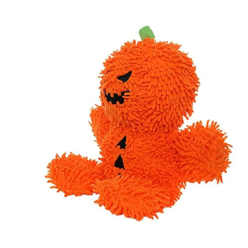 The image displays a side view of the MIGHTY® Dog Toy called "Microfiber Ball Pumpkin Man." The toy, which is bright orange and fuzzy, resembles a pumpkin with a jack-o'-lantern face. From this angle, the green stem on top is visible, along with the toy's round head, arms, and legs. The black triangular patches on the body are also partially visible. The toy's soft texture and minimal stuffing make it suitable for interactive play with dogs.