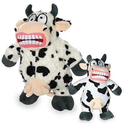 Two plush cow-shaped dog toys with black spots, wide grins showing large teeth, and udders, featuring comical and exaggerated expressions. One is larger and one is smaller