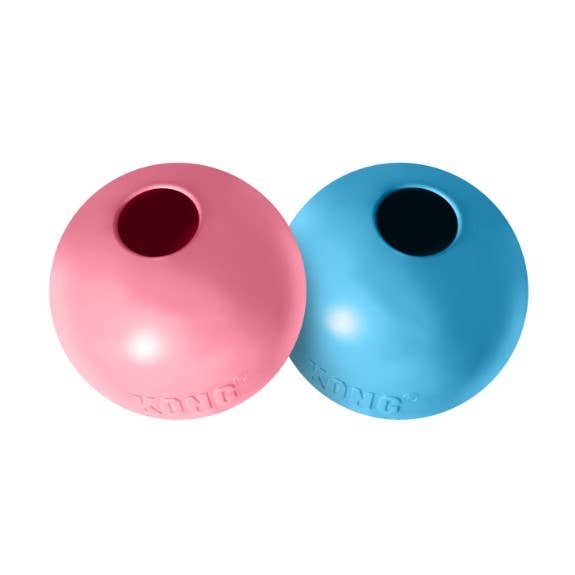 Pink and blue rubber balls with a central hole on a white background