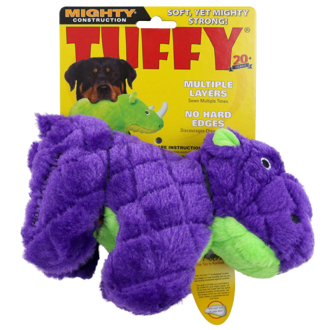 A purple and green plush dinosaur toy in front of its yellow retail packaging card, which reads 'Mighty Construction Tuffy'.