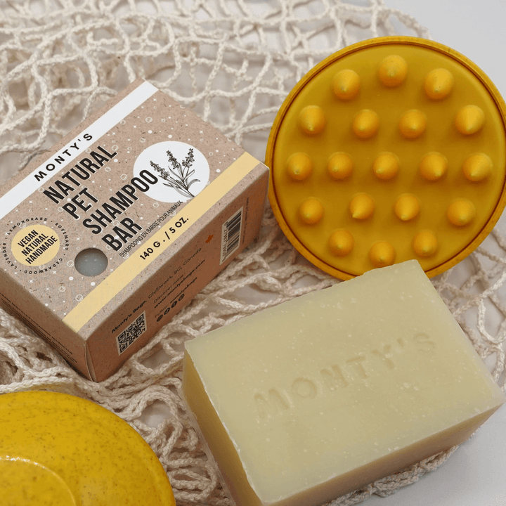 Monty's natural pet shampoo bar, eco-friendly packaging, and yellow grooming brush on a net background, perfect for gentle pet care.