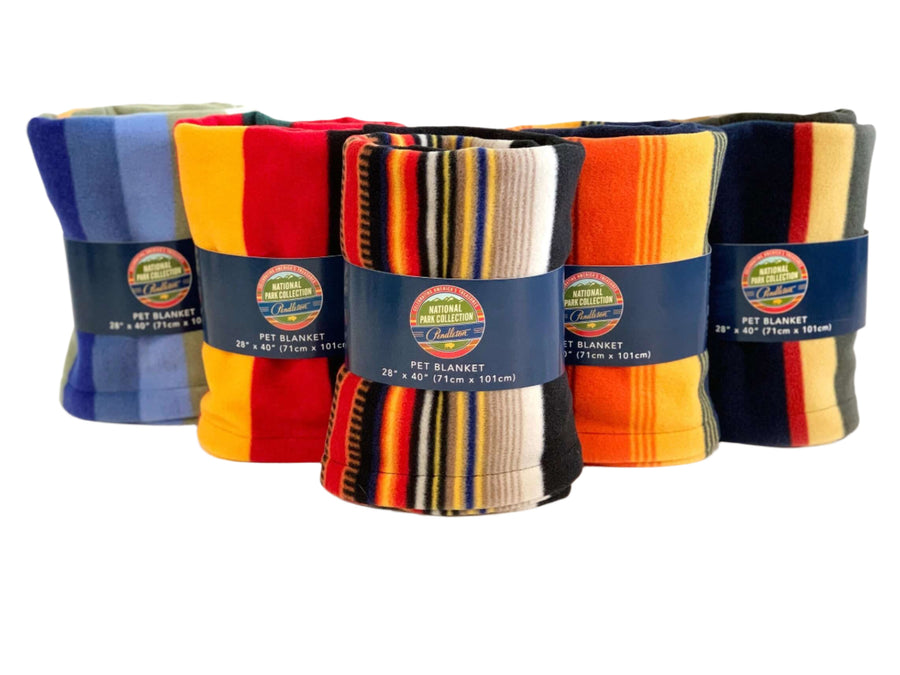 A collection of Pendleton National Park patterned plush pet throws for dogs, displayed in a row with varying colors and stripe patterns.