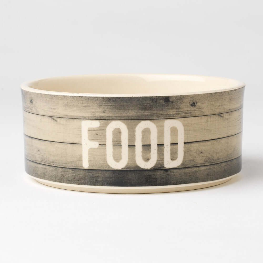A beige stoneware bowl with a rustic wood plank pattern and the word 'FOOD' in bold black letters in the center.