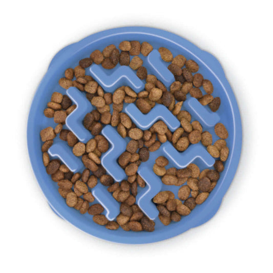 "Overhead view of a blue, round slow feeder dog bowl filled with dry kibble. The bowl features a raised maze-like pattern designed to slow down the dog's eating by making the food more challenging to access.