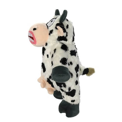 Side view of a plush cow-shaped dog toy with black spots, a wide grin showing large teeth, and udders, featuring a comical and exaggerated expression